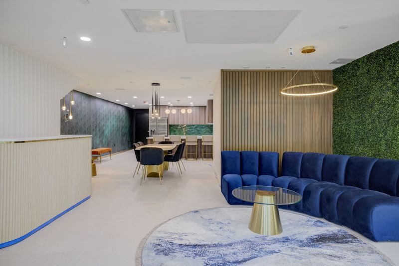 Resident lounge at The Felix on Fairfax with blue velvet seating and living greenery wall